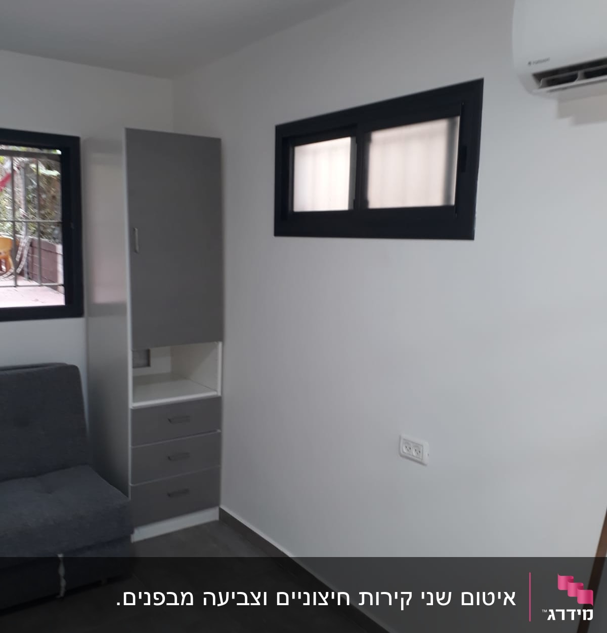 חלון אטום עם מסגרת שחורה על קיר לבן